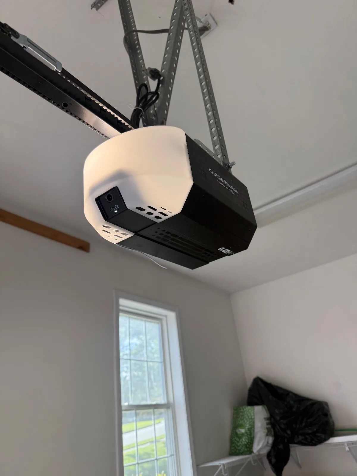 A newly installed garage door opener motor unit mounted to the ceiling in a garage in Canton, CT.